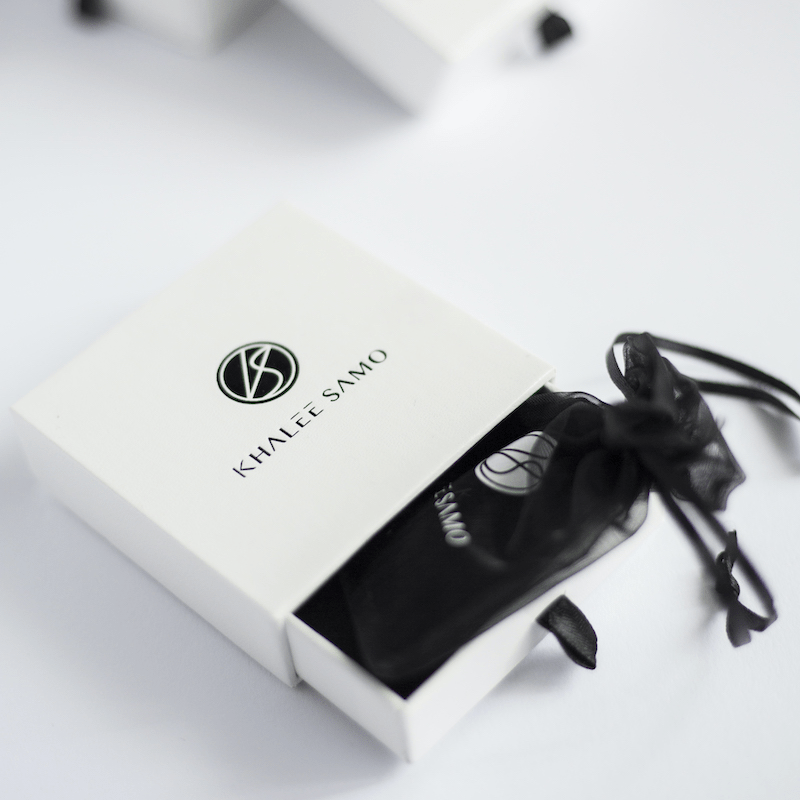 Schwarze Schmucktasche in weißer Khalee Sano Box, elegant, hochwertig, Geschenkverpackung.