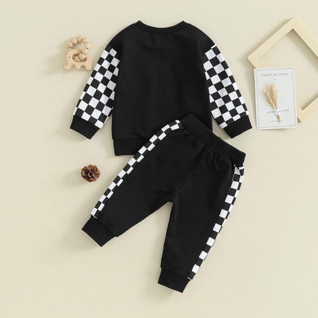 Schwarz-weiß kariertes Kinder-Sweatshirt und Jogginghose Set aus Baumwolle auf beigem Hintergrund.