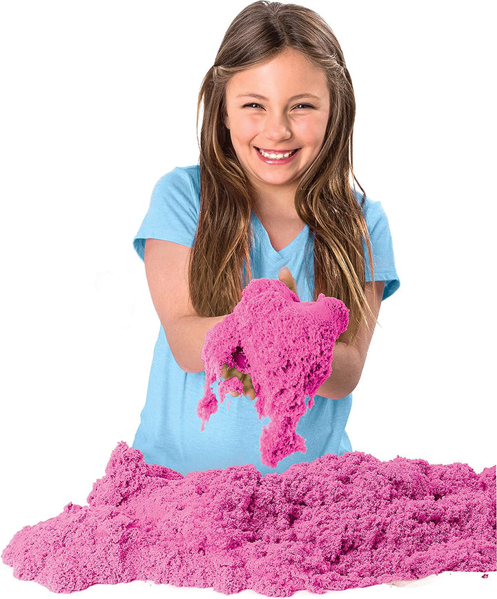 Mädchen spielt mit rosa Kinetic Sand, Spaßspielzeug für Kinder, sensorisches Spielmaterial.