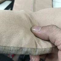 Beige Kissenbezug aus Leinen, Nahaufnahme, weiche Textur, handgehalten, Heimdekoration.