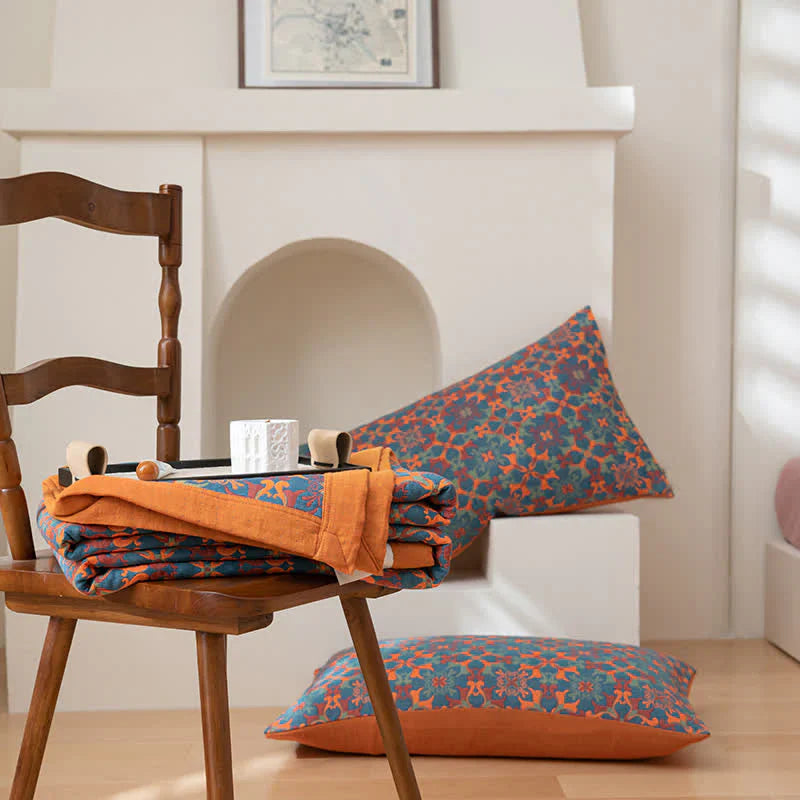 Orange-blaues Kissen-Set mit geometrischem Muster auf Holzstuhl, Wohnzimmer-Dekoration.