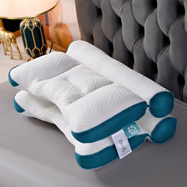 Weiße ergonomische Kissen mit blauen Akzenten auf grauem Bett, luxuriöses Schlafzimmerdekor.