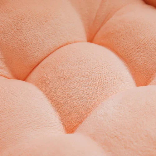 Pfirsichfarbene, gepolsterte Sitzkissenoberfläche aus weichem Stoff, Nahaufnahme.