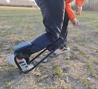 Person mit Knieorthese, schwarz, im Freien, auf Gras, für Unterstützung und Rehabilitation.