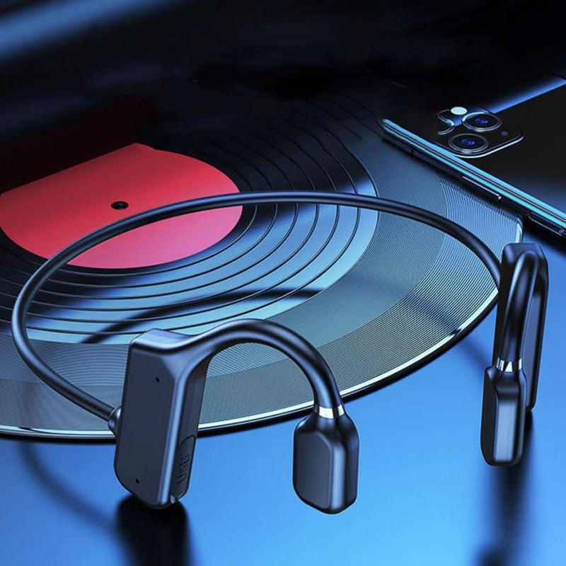 Drahtlose Knochenleitungs-Kopfhörer, schwarz, neben Schallplatte und Smartphone.