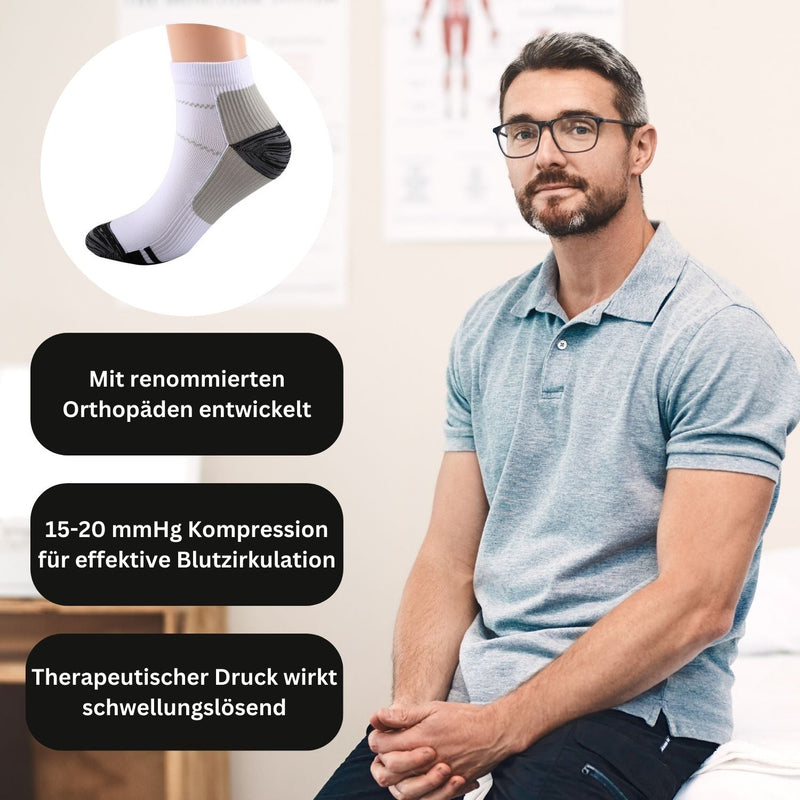 Mann in grauem Polohemd mit Kompressionssocken, 15-20 mmHg, für bessere Blutzirkulation.