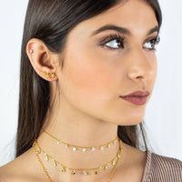 Frau mit goldenen Halsketten und Ohrringen, Kristallanhänger, modischer Schmuck.