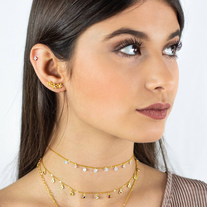 Frau mit goldenen Halsketten und Ohrringen, Kristallanhänger, modischer Schmuck.