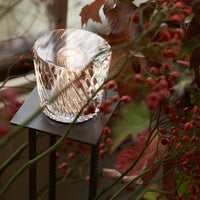 Kristall-Tischlampe mit LED-Licht, dekorative Beleuchtung, Herbstlaub im Hintergrund.