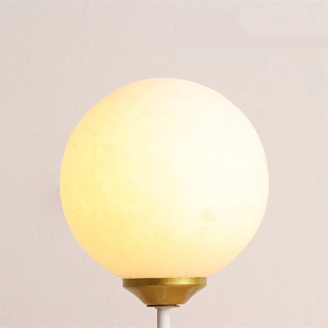 Kugelförmige Tischlampe, warmweißes Licht, goldener Sockel, modernes Design, Innenbeleuchtung.