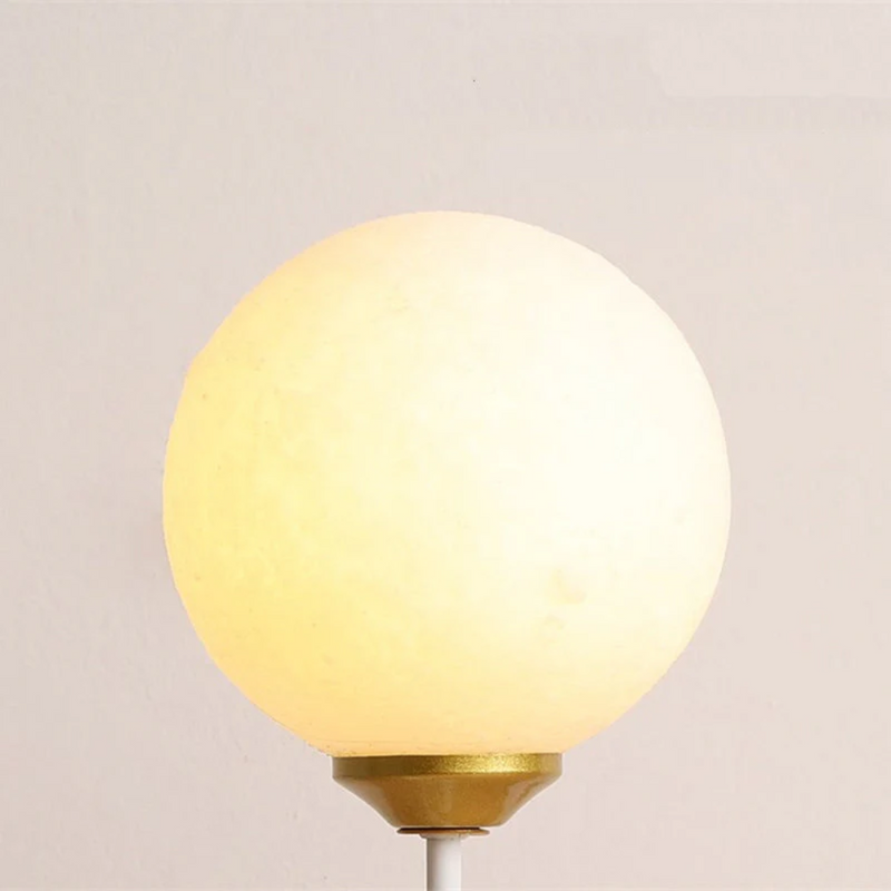 Kugelförmige Tischlampe, warmweißes Licht, goldener Sockel, modernes Design, Innenbeleuchtung.