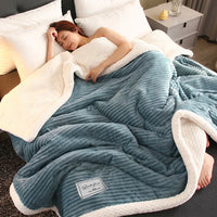 Frau schläft unter blau-weißer Plüschdecke im Bett, gemütlich, Schlafzimmer, Entspannung.