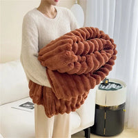 Frau hält braune, plüschige Decke im Wohnzimmer, gemütliche Wohnkultur, weiches Material.