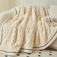 Weiche beige Flanell-Fleece-Decke, gemütlich, warm, für Herbst und Winter, auf Sofa drapiert.