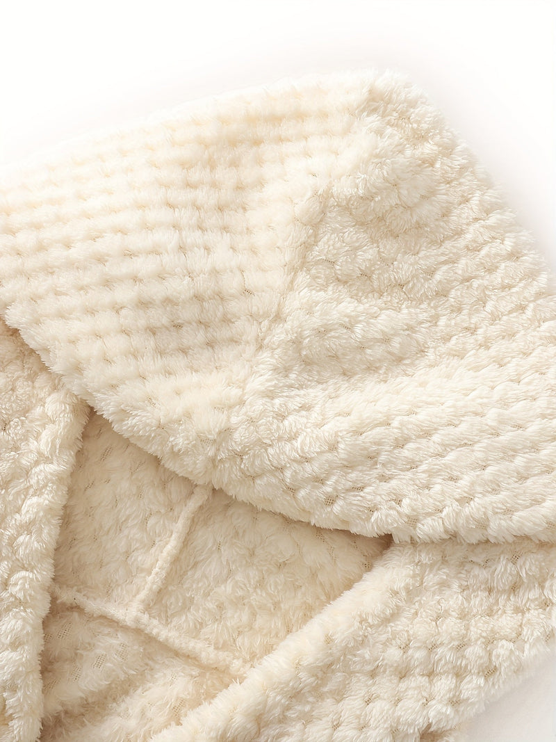 Beige Plüschdecke, weiches Material, waffelartige Textur, gemütlich, warm, Heimdekoration.