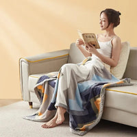 Frau liest auf Sofa mit bunter Kuscheldecke, gemütliches Wohnzimmer, Entspannung, Inneneinrichtung.