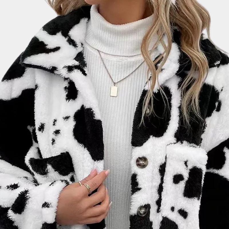 Frau in schwarz-weißer Kuhfelljacke, Rollkragenpullover, Halskette, modisch, Wintermode.