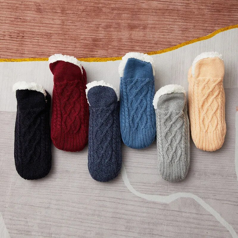 Sechs Paar gestrickte Hausschuhe in Schwarz, Rot, Blau, Grau und Beige mit Fleecefutter.
