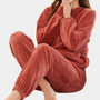 Frau in rotem Fleece-Pyjama-Set, gemütlich, warm, langärmelig, für Damen, Winterkleidung.