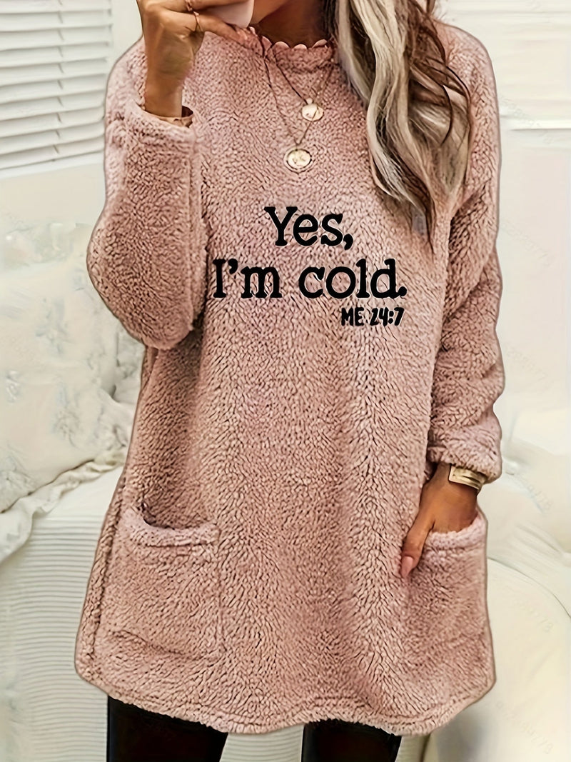Frau in rosa Fleece-Pulloverkleid mit Taschen, Aufdruck "Yes, I'm cold", gemütliche Wintermode.