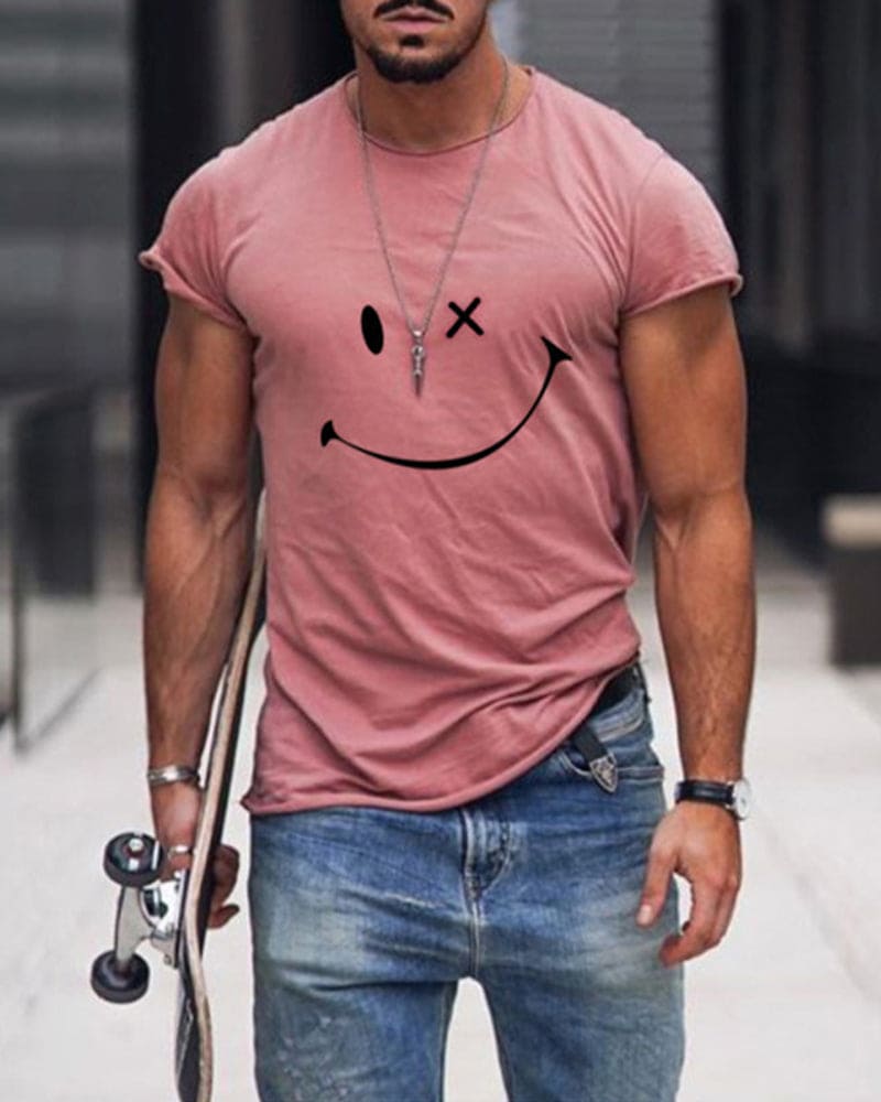 Mann in rosa T-Shirt mit Smiley-Design, Jeans, Skateboard, urbaner Hintergrund.