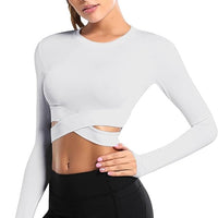 Frau in weißem Langarm-Crop-Top, Fitnessmode, Sportbekleidung, elastisch, modern.
