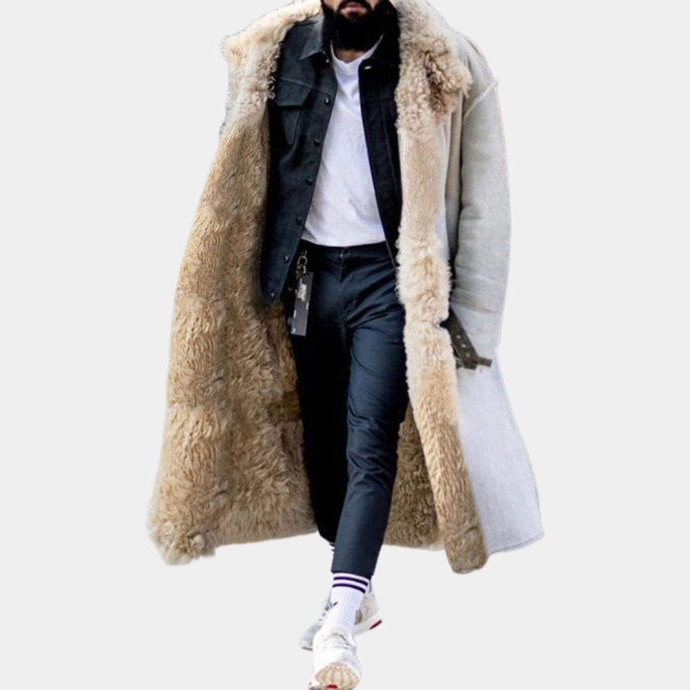 Mann in weißem Lammfellmantel, schwarzer Jacke, weißem Hemd, schwarzer Hose und Sneakers.