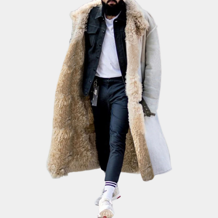 Mann in weißem Lammfellmantel, schwarzer Jacke, weißem Hemd, schwarzer Hose und Sneakers.