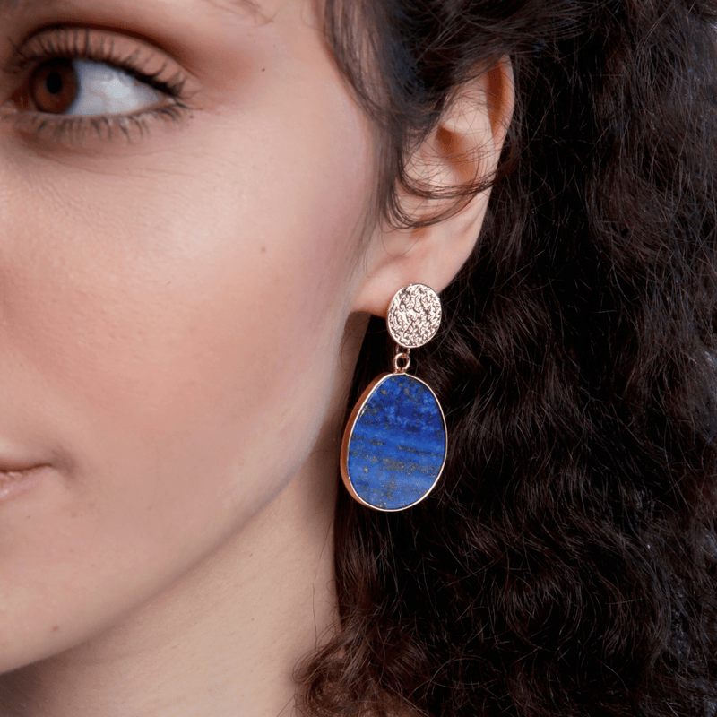 Frau mit blauem Lapis-Lazuli-Ohrring, oval, goldgefasst, eleganter Schmuck.