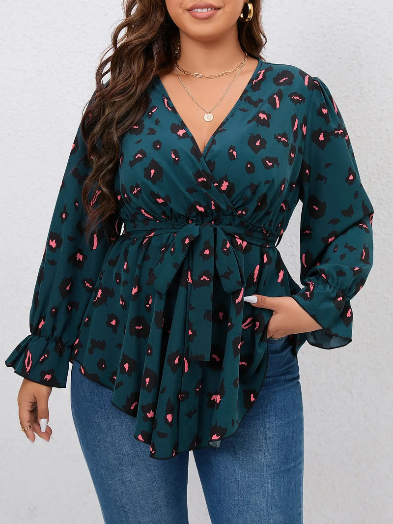 Frau in grünem, langärmligem Leopardenblusen-Top mit V-Ausschnitt und Jeans.