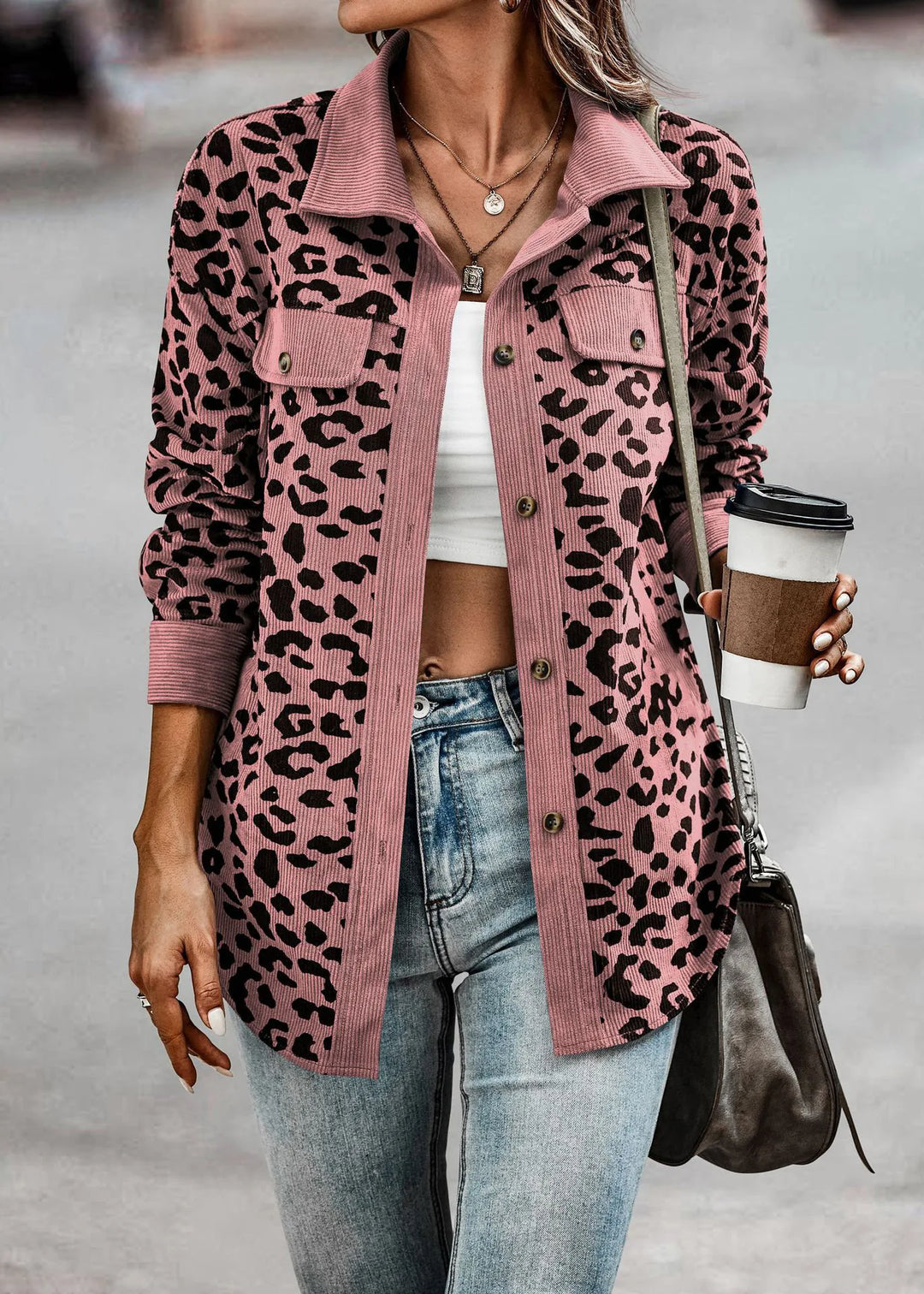 Frau in rosa Leopardenmuster-Jacke, Langarm, mit Kaffeebecher, modisch, Herbst/Winter 2024.