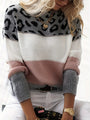 Frau in modischem Strickpullover mit Leopardenmuster, rosa und grauen Streifen, goldene Accessoires.