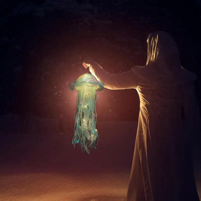 Person in Umhang hält leuchtende Laterne in der Dunkelheit, mystische Atmosphäre, Nacht.