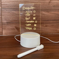 LED-Schreibtafel mit Einkaufszettel, weißer Sockel, Stift, Holzuntergrund, moderne Notiztafel.