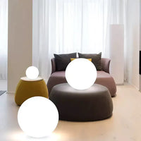 Moderne Wohnzimmerbeleuchtung mit runden LED-Lampen, grauem Sofa und gelbem Hocker.