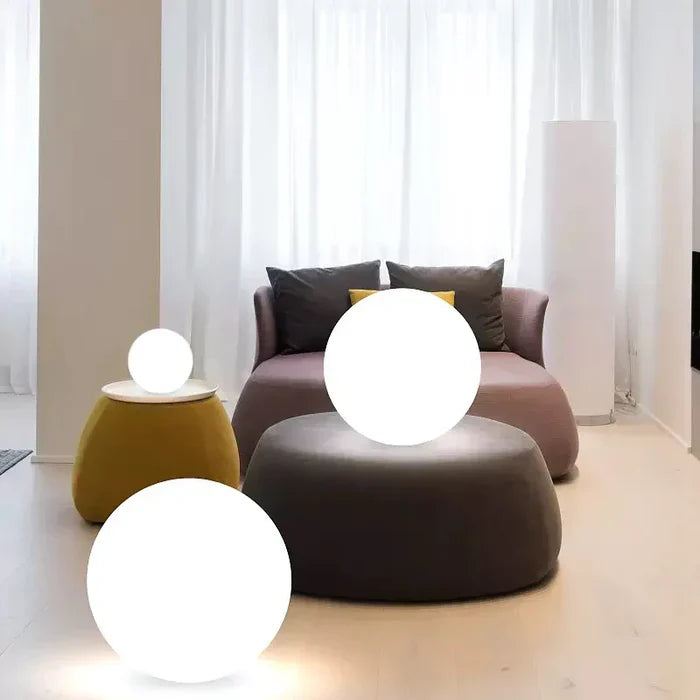 Moderne Wohnzimmerbeleuchtung mit runden LED-Lampen, grauem Sofa und gelbem Hocker.