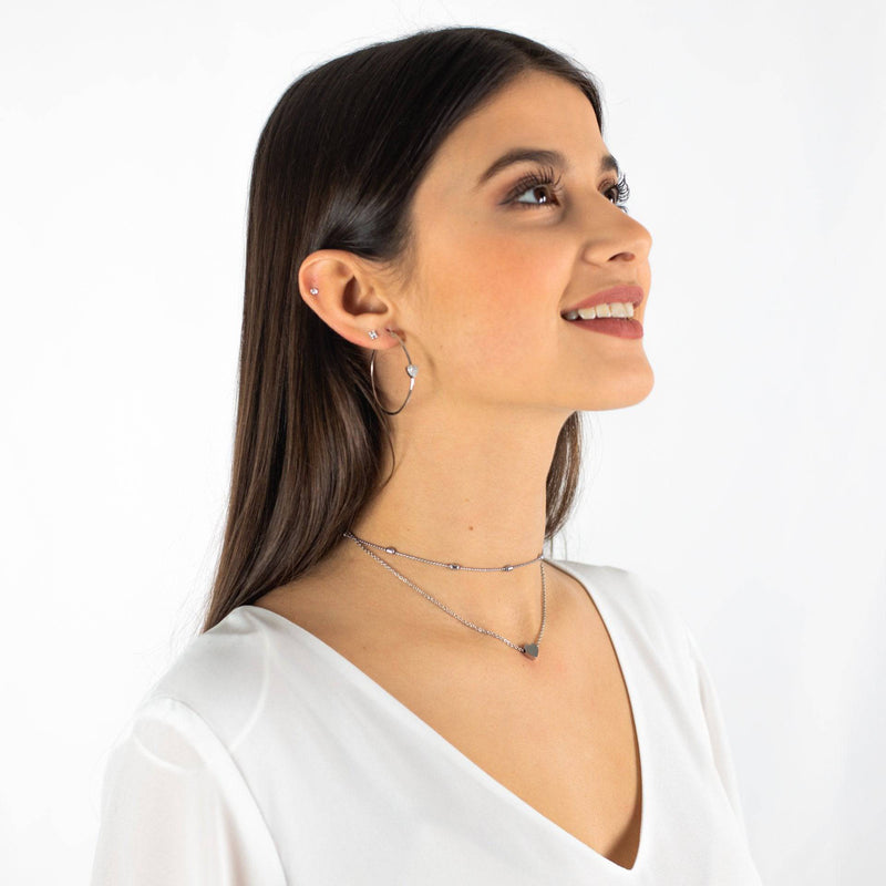 Frau mit silberner Halskette, Ohrringen, weißem Oberteil, Schmuck, Modeaccessoires.