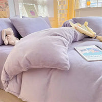 Lila Bettwäsche-Set aus Samt mit Kissen, Tulpenstrauß und Plüschtier auf Bett im Schlafzimmer.