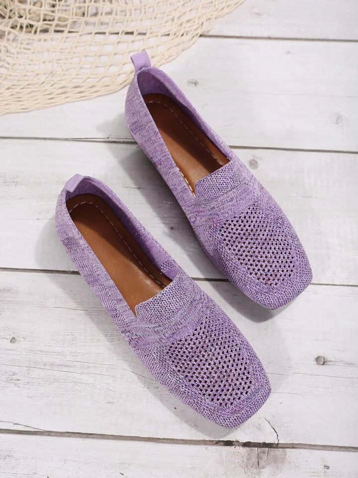 Lila Damen-Loafer aus Strickgewebe auf Holzboden, atmungsaktiv und stilvoll.