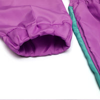 Lila Kinder-Regenjacke, wasserabweisend, mit grünen Akzenten, Nahaufnahme der Ärmel.