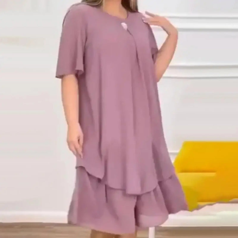 Frau in fliederfarbenem, lockerem Kleid, knielang, aus leichtem Stoff, modisch, elegant.