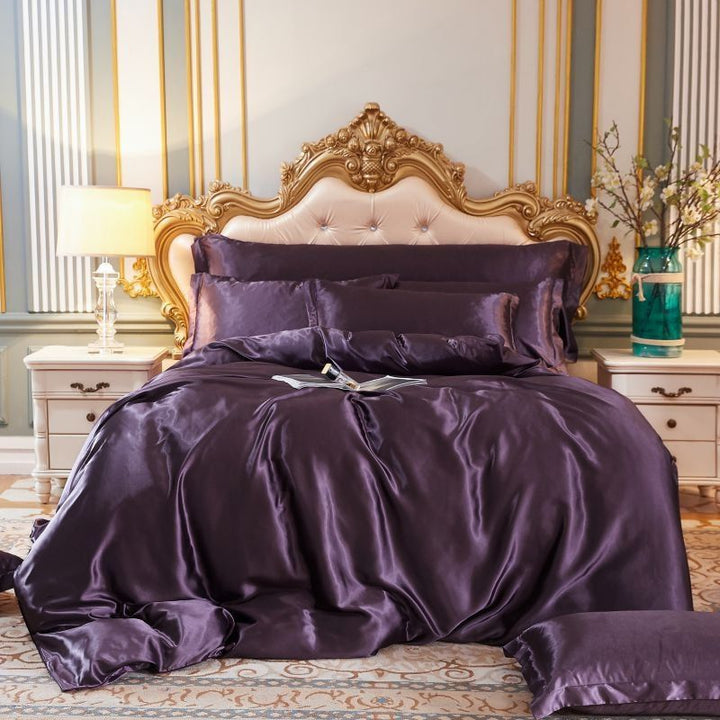 Luxuriöses lila Seidensatin-Bettwäsche-Set auf elegantem Bett mit goldener Kopfstütze.