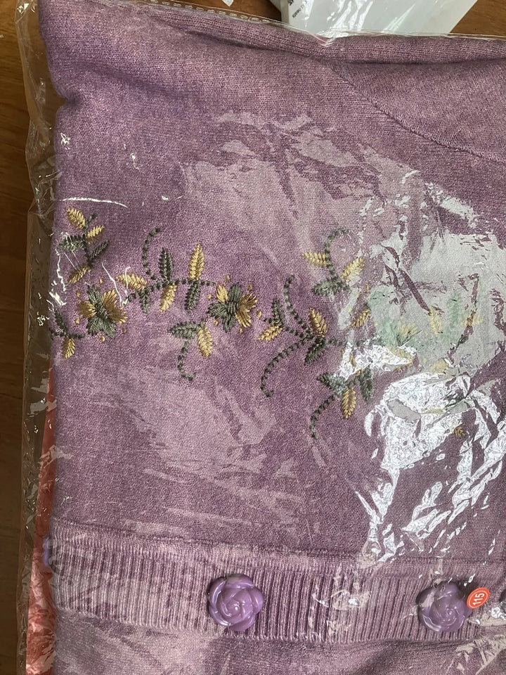 Lila Strickjacke mit Blumenstickerei, Knöpfen, Damenmode, Baumwolle, verpackt in Plastik.