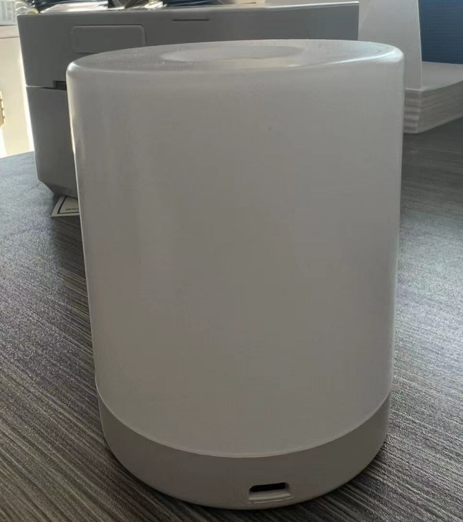 Weißer zylindrischer Luftbefeuchter auf Tisch, modernes Design, USB-Anschluss, Raumklima verbessern.