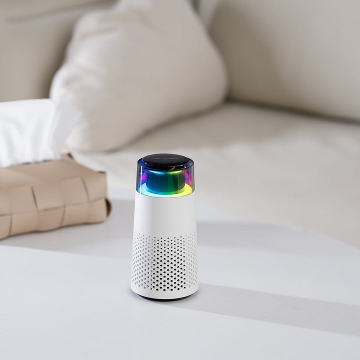 Weißer Bluetooth-Lautsprecher mit LED-Licht, modernem Design, auf einem Tisch im Wohnzimmer.