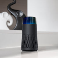 Schwarzer Bluetooth-Lautsprecher mit LED-Licht, modernem Design, auf weißem Tisch.