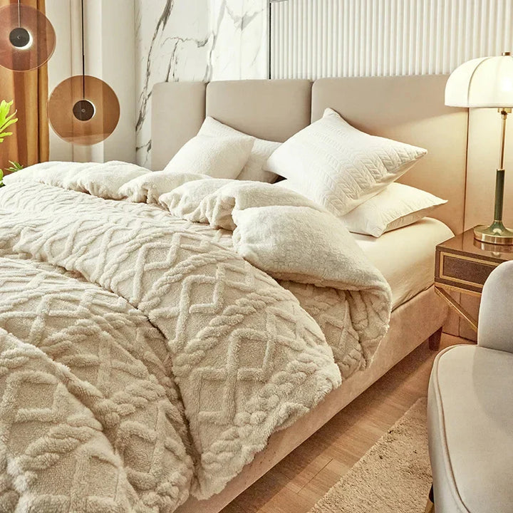 Beige Bett mit Plüschdecke und Kissen, modernes Schlafzimmer, gemütliche Einrichtung, Holzfußboden.