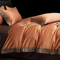 Luxuriöse orangefarbene Seidenbettwäsche mit H-Muster, elegant und hochwertig für Schlafzimmer.