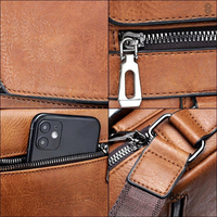 Braune Ledertasche mit Reißverschluss, Smartphone-Fach, verstellbarem Riemen, 8 cm Breite.