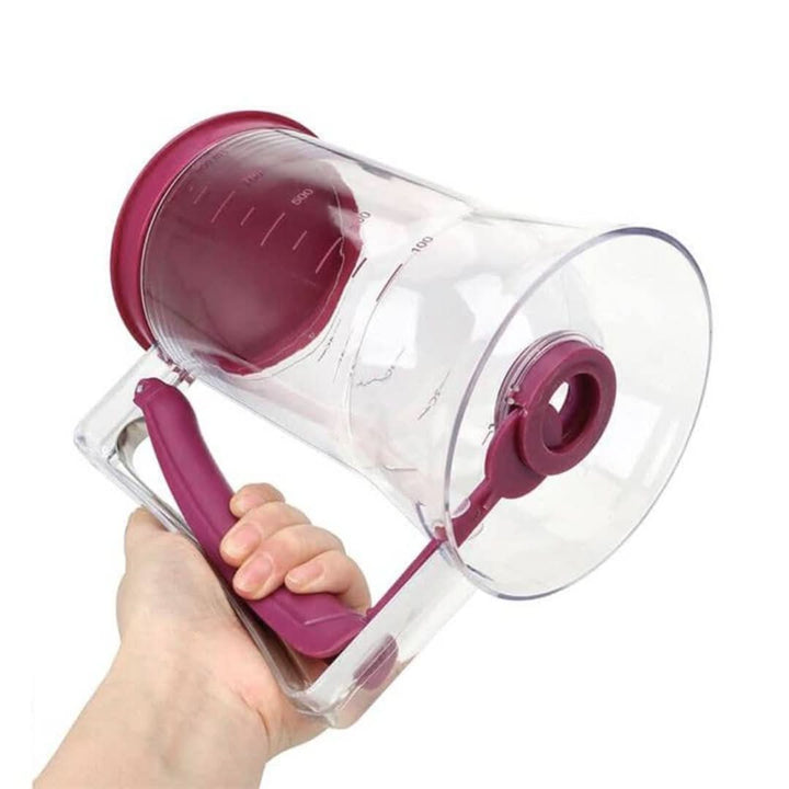 Handgehaltener Teigspender aus transparentem Kunststoff mit rotem Griff und Deckel.